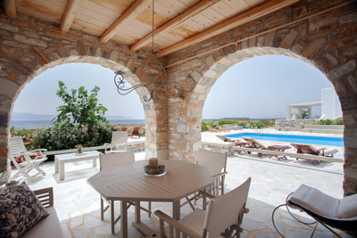 The shaded veranda of Villa Sand, next to the pool and with view to the sea. 